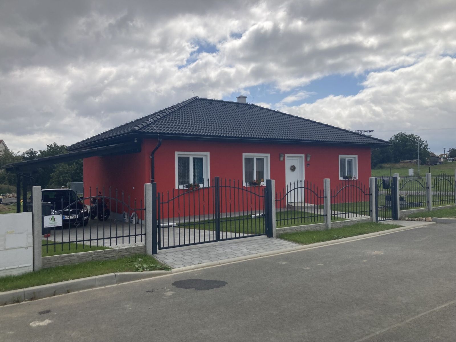 Realizace - bungalov se sytě červenou fasádou a valbovou střechou